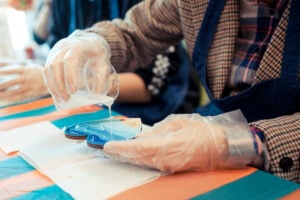 Resin artist pouring epoxy over a wooden board in a studio